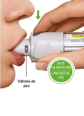 A hand holding a white medical device against a person's lips with a green arrow pointing downward and informational text