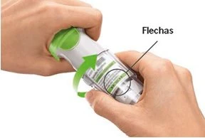 Two hands holding a cylindrical medical device with a curved green arrow indicating clockwise rotational movement
