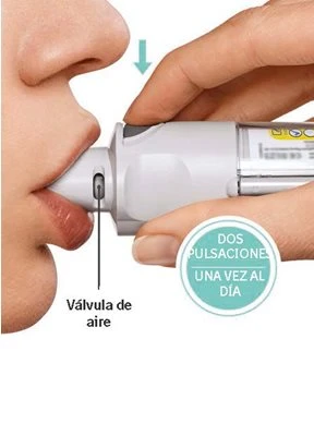 A hand holding a white medical device against a person's lips with a downward arrow and the label 'válvula de aire'