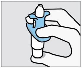 Una mano tiene una penna iniettore azzurra e bianca per preparare l'iniezione su uno sfondo grigio chiaro
