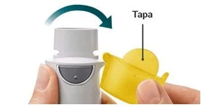 A hand holding a white medical device while