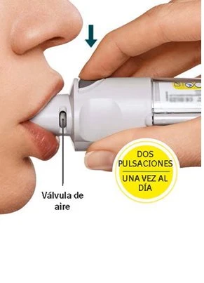 Close-up of a person using a white medical device placed against the lips, with one hand holding it and informational text