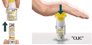 A hand pressing a white and yellow medical device onto a flat surface until a click is heard for