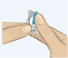 Due mani tengono e separano un piccolo contenitore medico con una parte superiore blu e una base grigia per l'apertura del dispositivo