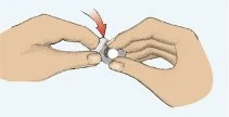 Due mani tengono e premono un dispositivo medico circolare con una freccia rossa che indica la direzione della pressione verso il basso