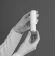 Two hands hold vertically a white cylindrical bottle against a uniform dark background