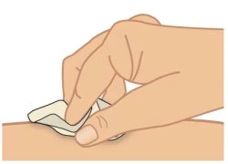 A hand gently applies a patch or adhesive dressing to the skin surface of an arm or leg