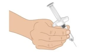 A hand firmly holding a syringe with needle pointing downward, ready for