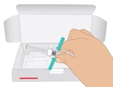 A hand grasping a white medical device at