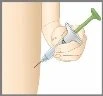 Рука держит шприц с иглой и зелёным поршнем для проведения инъекции