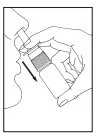 A hand holds a cylindrical bottle and tilts it downward following the direction indicated by a black arrow toward a human profile