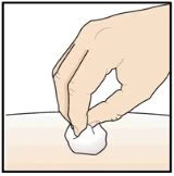 Una mano tiene un batuffolo di cotone bianco e lo preme delicatamente sulla pelle per applicare una medicazione o pulire una zona del corpo