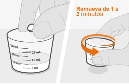Two hands manipulating a graduated measuring cup containing a clear liquid; one hand holds the container and the other pours