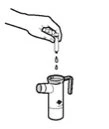Una mano tiene una fiala sopra un dispositivo medico cilindrico da cui cadono delle gocce di liquido