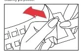 Two hands opening a medicine package with a red arrow indicating the direction of movement to remove the top layer
