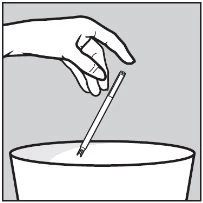 A hand holds an injection pen tilted over a white container for the