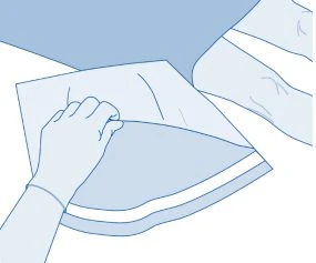 A hand gently opens a white plastic wrapper to extract the medication contents