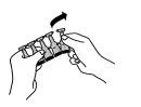 Two hands holding a medical device while a black arrow indicates the rotational movement to the