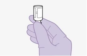 Una mano guantata tiene verticalmente un piccolo contenitore cilindrico bianco con una base stretta su sfondo chiaro