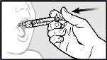 A hand holds a syringe without a needle and gently inserts it into an open child's mouth to administer liquid medication