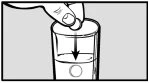 A hand inserts a capsule into the