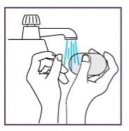 Due mani lavano una saponetta sotto il getto d'acqua che esce da un rubinetto aperto in un lavandino