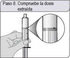 A hand holding a vertical syringe with a circular magnifier showing the liquid level inside