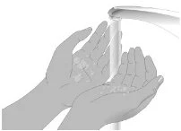Due mani aperte sotto un rubinetto che eroga un getto d'acqua per il lavaggio delle mani con presenza di bolle di sapone