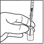 A hand holds a small glass vial while inserting the
