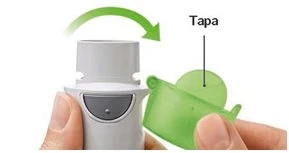 Hands removing a translucent green cap from a white medical device, with a curved green arrow indicating the rotational movement