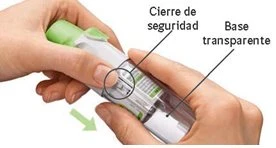 Two hands holding a transparent medical device showing safety lock instructions and transparent base, with a green downward arrow