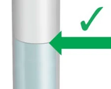 Szczegół cylindrycznego urządzenia medycznego z zieloną strzałką wskazującą na połączenie górnej białej części i dolnej niebieskiej części z zielonym znakiem zatwierdzenia