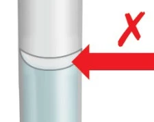 Illustrazione medica di un dispositivo cilindrico con una freccia rossa che punta verso la giunzione tra la parte superiore bianca e quella inferiore azzurra con una X rossa sopra