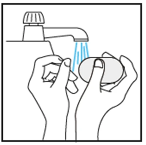Due mani lavano una saponetta sotto un getto d'acqua che esce da un rubinetto di un lavandino