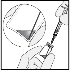 A hand holding a vial with attached needle and a