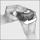 Two hands hold a circular medical device with a curved white arrow indicating a leftward rotational movement
