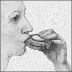 Profile view of a person holding a container with a spout to the mouth to take a liquid medication or solution