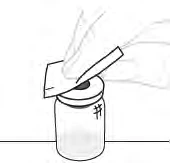 A hand holding a scalpel to puncture the top of a cylindrical medicine vial for preparation