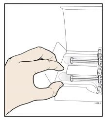A hand grasps the base of a medical device to prepare the