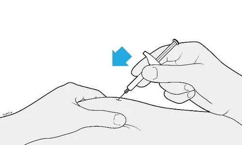 A hand holds a syringe with needle pointing toward the skin of an arm while a second hand supports the area of the