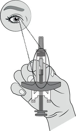 Disegno tecnico che mostra una mano che impugna una siringa con un ingrandimento dell'occhio che indica il punto di applicazione del farmaco