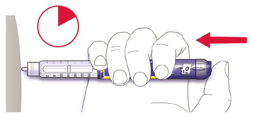 A hand holding an injector pen horizontally toward a gray surface with a red arrow and a circular gauge at the top