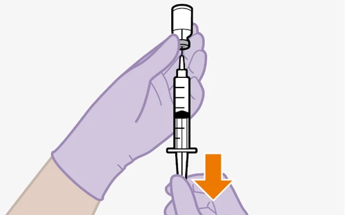 A gloved hand holding a syringe with needle inserted into a vial while an orange arrow points downward toward the vial