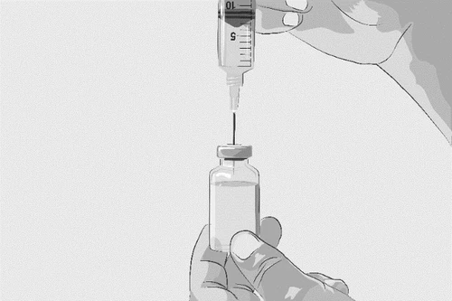 A hand holds a glass vial while the