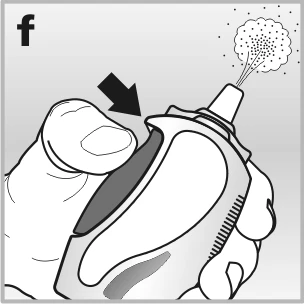 Una mano tiene un dispositivo medico con una freccia nera che indica di premere il pulsante superiore per rilasciare una nuvola di spray