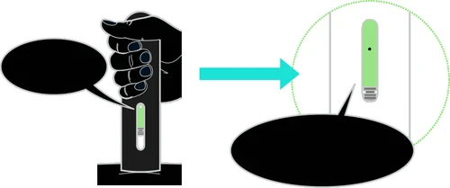 Una mano impugna un dispositivo medico nero con un indicatore verde che punta verso un ingrandimento circolare del componente luminoso