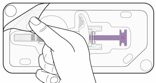 Una mano solleva l'angolo di una pellicola trasparente da un contenitore rettangolare che racchiude una siringa con stantuffo viola