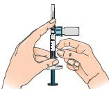 Due mani tengono una siringa verticale per aspirare il contenuto da un piccolo flaconcino di vetro con tappo blu tramite un ago sottile