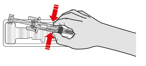 A hand pressing with fingers on the top of a syringe to push it downward