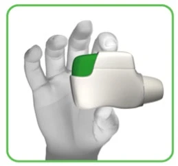 Una mano con guante sostiene un dispositivo médico blanco con un botón verde para el